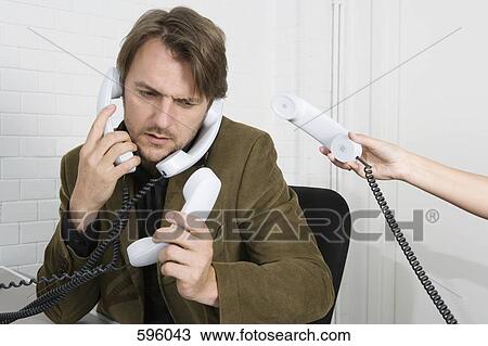 A businessman with four telephone receivers View Large Photo Image Stock Image - A businessman with four telephone receivers. Fotosearch