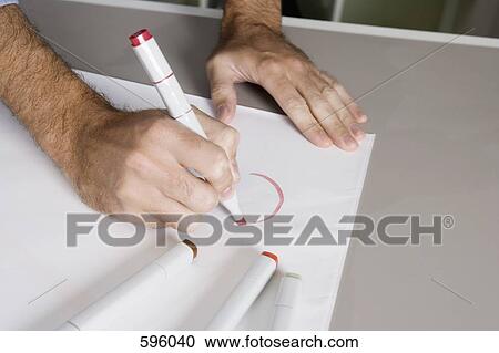 A man drawing on a sheet of paper with a felt tip pen View Large Photo Image Stock Image - A man drawing on a sheet of paper with a felt tip pen. Fotosearch