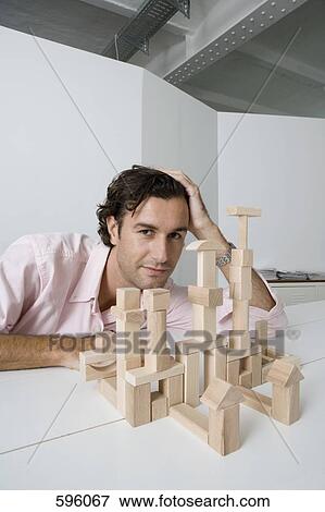 A man using wooden building blocks at a desk View Large Photo Image Stock Photo - A man using wooden building blocks at a desk. Fotosearch