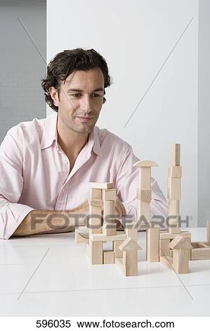 A man using wooden building blocks at a desk View Large Photo Image Stock Photography - A man using wooden building blocks at a desk. Fotosearch