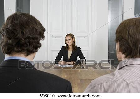 A woman meeting with two men in a board room View Large Photo Image Stock Image - A woman meeting with two men in a board room. Fotosearch