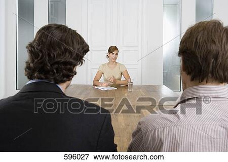 A woman meeting with two men in a board room View Large Photo Image Stock Photo - A woman meeting with two men in a board room. Fotosearch