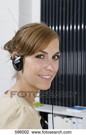 Stock Image - A woman wearing a telephone headset. Fotosearch