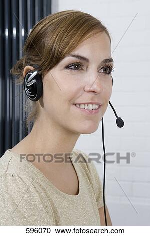 A woman wearing a telephone headset View Large Photo Image Stock Image - A woman wearing a telephone headset. Fotosearch