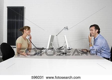 Office colleagues working opposite each other View Large Photo Image Stock Image - Office colleagues working opposite each other. Fotosearch