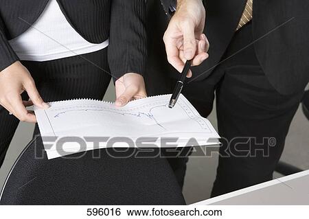 Two business people looking at a graph View Large Photo Image Stock Photograph - Two business people looking at a graph. Fotosearch