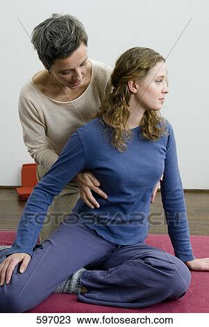 A mature woman assisting a young woman in yoga exercise View Large Photo Image Stock Image - A mature woman assisting a young woman in yoga exercise. Fotosearch