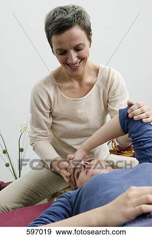 A Mature woman assisting a young woman with stretching View Large Photo Image Stock Photo - A Mature woman assisting a young woman with stretching. Fotosearch