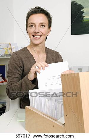 Stock Photo - A Mature woman doing paperwork. Fotosearch