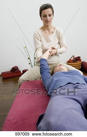A Mature Woman instructing a young woman in stretching exercise View Large Photo Image Stock Photography - A Mature Woman instructing a young woman in stretching exercise. Fotosearch