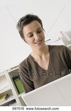 A mature woman working in office View Large Photo Image Stock Photograph - A mature woman working in office. Fotosearch