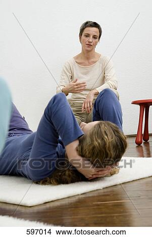 A woman instructing others in stretching exercises View Large Photo Image Picture - A woman instructing others in stretching exercises. Fotosearch