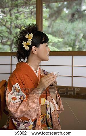A woman wearing a kimono and drinking tea View Large Photo Image Stock Image - A woman wearing a kimono and drinking tea. Fotosearch