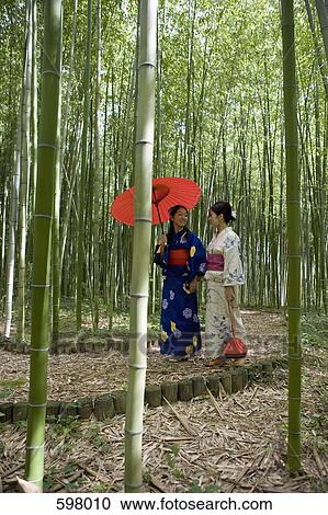 Two woman wearing kimonos walking through a bamboo grove View Large Photo Image Stock Image - Two woman wearing kimonos walking through a bamboo grove. Fotosearch