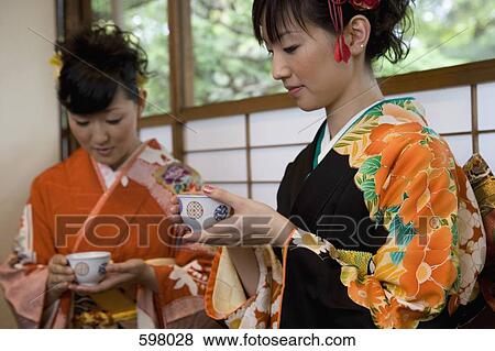 Two women wearing kimonos drinking tea View Large Photo Image Stock Photo - Two women wearing kimonos drinking tea. Fotosearch