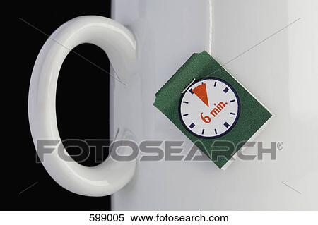 Stock Photography - A teabag label hanging from a mug. Fotosearch