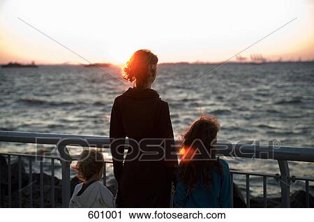 A mother and two children looking out to sea View Large Photo Image Stock Image - A mother and two children looking out to sea. Fotosearch