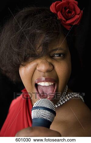 Stock Image - A singer holding a microphone. Fotosearch