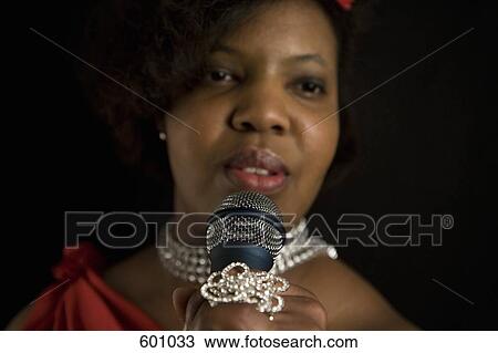 Stock Image - A singer holding a microphone. Fotosearch