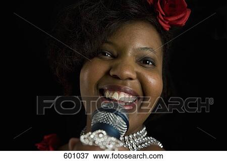 A singer holding a microphone View Large Photo Image Stock Photo - A singer holding a microphone. Fotosearch