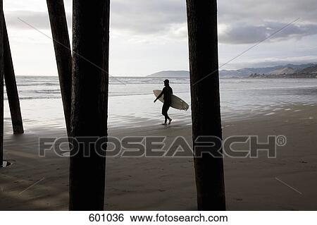 A surfer walking on the beach View Large Photo Image Stock Photograph - A surfer walking on the beach. Fotosearch