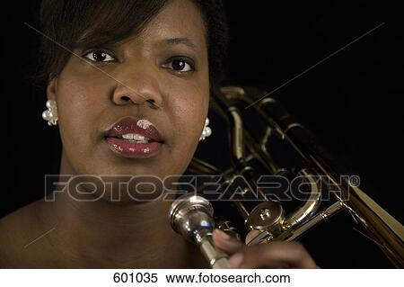 A woman holding a trombone View Large Photo Image Stock Photography - A woman holding a trombone. Fotosearch
