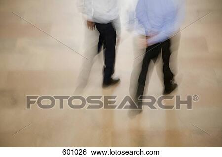 Blurred view of two men walking View Large Photo Image Stock Photograph - Blurred view of two men walking. Fotosearch