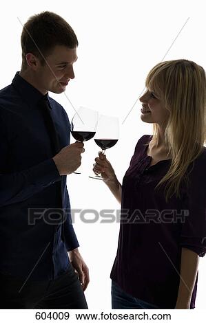 A heterosexual couple toasting wine glasses View Large Photo Image Stock Photo - A heterosexual couple toasting wine glasses. Fotosearch