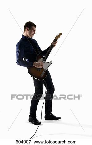 Stock Photo - Studio shot of a man playing an electric guitar. Fotosearch