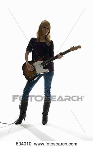 Studio shot of a woman playing an electric guitar View Large Photo Image Stock Image - Studio shot of a woman playing an electric guitar. Fotosearch