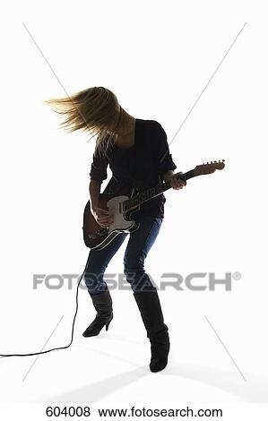 Studio shot of a woman playing an electric guitar View Large Photo Image Stock Photo - Studio shot of a woman playing an electric guitar. Fotosearch