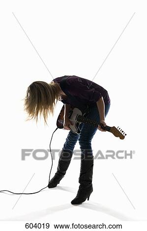 Stock Photo - Studio shot of a woman playing an electric guitar. Fotosearch