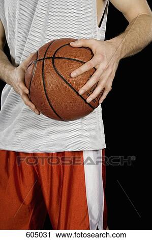 A basketball player holding a basketball View Large Photo Image Stock Image - A basketball player holding a basketball. Fotosearch