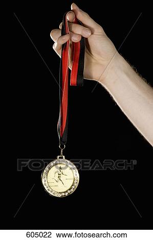 A hand holding a gold medal View Large Photo Image Stock Image - A hand holding a gold medal. Fotosearch