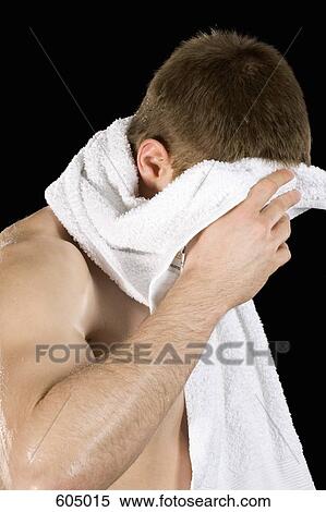 Stock Photography - A man wiping his head with a towel. Fotosearch
