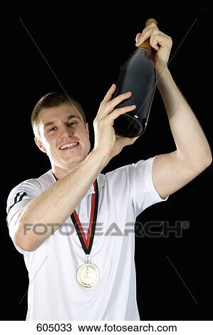 Stock Image - A sportsperson celebrating with champagne. Fotosearch