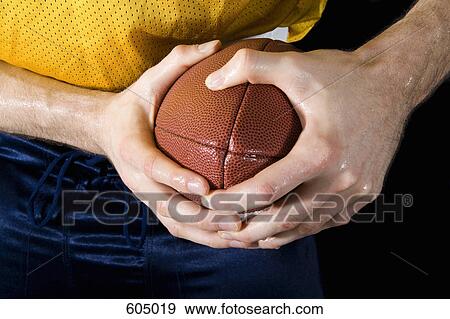 An American football player holding a ball View Large Photo Image Stock Photo - An American football player holding a ball. Fotosearch