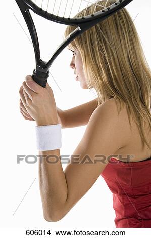 Picture - A close-up studio shot of a female tennis player holding a tennis racket. Fotosearch