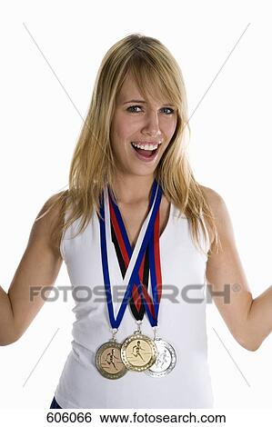 A female athlete wearing three winning medals View Large Photo Image Stock Photograph - A female athlete wearing three winning medals. Fotosearch