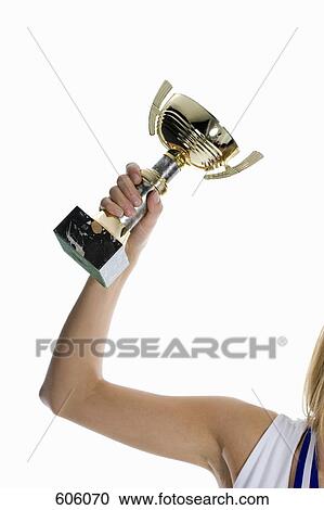 A female athlete's arm holding up a winning trophy View Large Photo Image Stock Image - A female athlete's arm holding up a winning trophy. Fotosearch