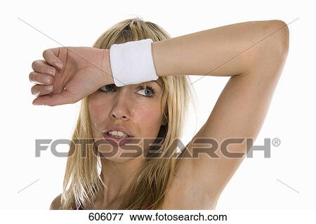 A portrait of a woman sweating and wiping her brow View Large Photo Image Stock Photo - A portrait of a woman sweating and wiping her brow. Fotosearch