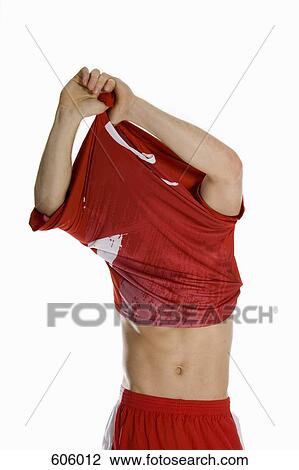 An male athlete taking off his shirt View Large Photo Image Stock Image - An male athlete taking off his shirt. Fotosearch