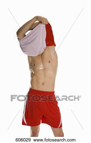 An male athlete taking off his shirt View Large Photo Image Stock Photo - An male athlete taking off his shirt. Fotosearch