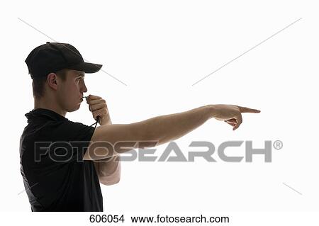 Side view studio portrait of a referee blowing a whistle and pointing View Large Photo Image Picture - Side view studio portrait of a referee blowing a whistle and pointing. Fotosearch