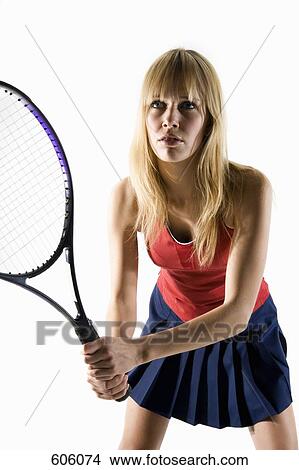 Picture - studio portrait of a female tennis player holding a tennis racket. Fotosearch