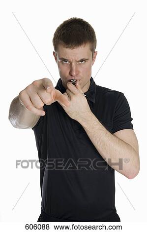 Stock Photo - Studio portrait of a referee blowing a whistle and pointing. Fotosearch