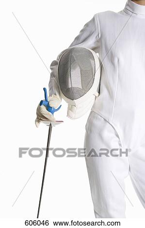 Stock Photograph - Studio shot of a female fencer holding a fencing mask and fencing foil. Fotosearch