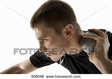Studio shot of a male track and field athlete holding a shot put ball View Large Photo Image Stock Photo - Studio shot of a male track and field athlete holding a shot put ball. Fotosearch