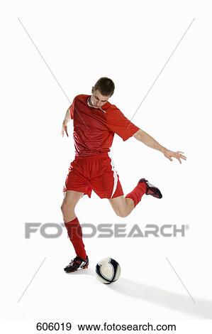 Studio shot of a soccer player kicking a soccer ball View Large Photo Image Stock Photo - Studio shot of a soccer player kicking a soccer ball. Fotosearch