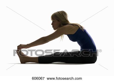 Studio shot of a woman stretching and touching her toes View Large Photo Image Stock Photo - Studio shot of a woman stretching and touching her toes. Fotosearch